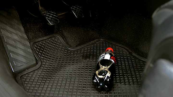 irtonainen juomapullo ohjaamon lattialla