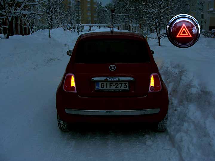 hämärässä lumitöyrään viereen pysähtynyt auto