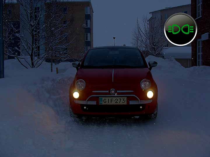 hämärässä lumitöyrään viereen pysähtynyt auto