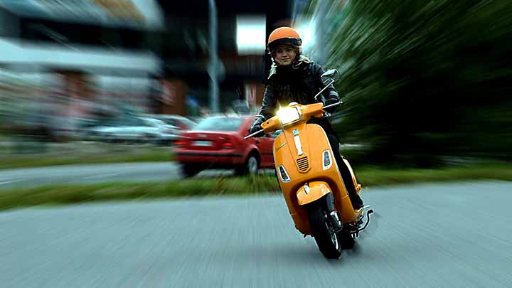 mopoilija kaartaa vauhdissa; tausta on sumea