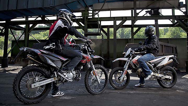 kaksi mopoilijaa varusteet päällä valmiina lähtöön