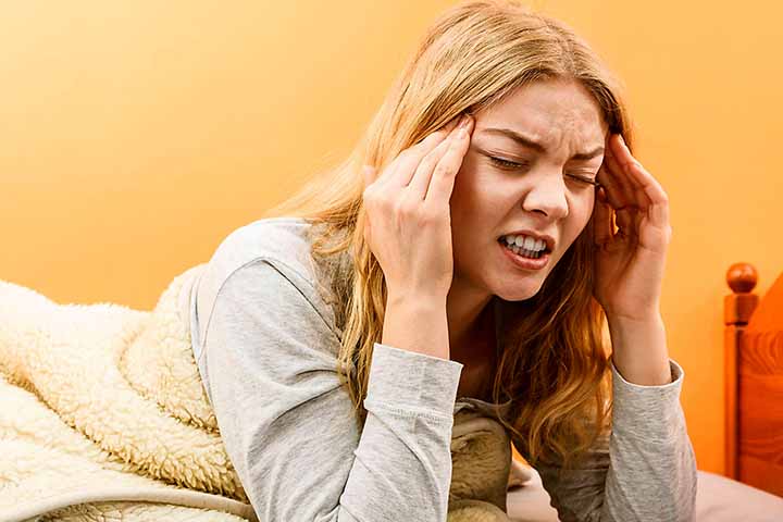 nainen painaa sormillaan ohimoitaan