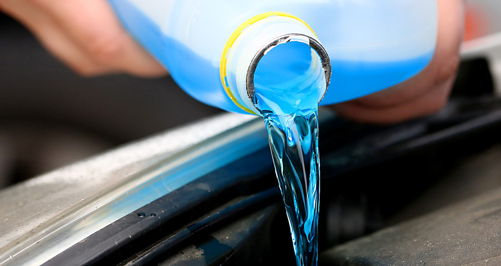 sinistä pesunestettä kaadetaan pullosta